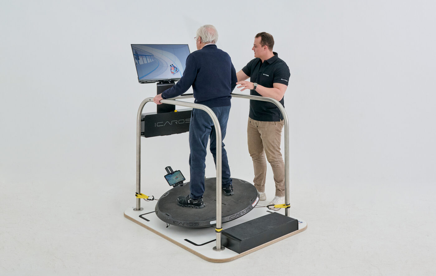 Older man training on the ICAROS Guardian with an ICAROS trainer assisting