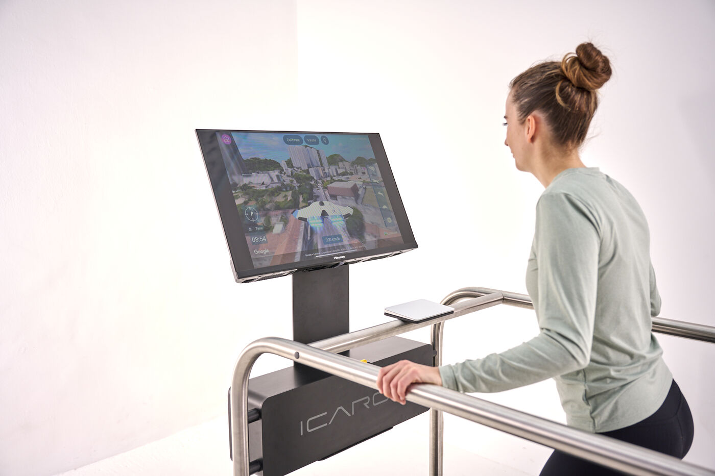 Woman training on the ICAROS Guardian in front of a screen